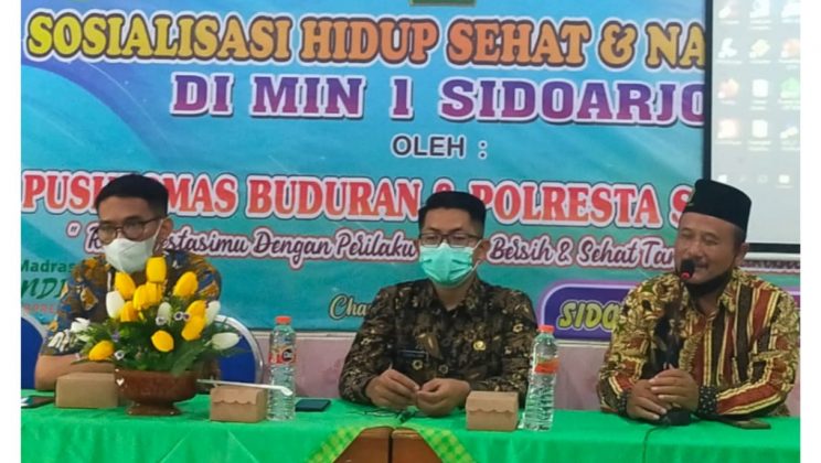 Sosialisasi Hidup Sehat dan Narkoba di MIN 1 Sidoarjo Kamis, tanggal 10 November 2022, MIN 1 Sidoarjo mengadakan sosialisasi tentang PHBS kepada peserta didik di MIN 1 Sidoarjo. Karena salah satu yang harus diperhatikan dalam pelaksanaan pembelajaran tatap muka adalah PHBS, yaitu Penerapan Hidup Bersih dan Sehat. Acara tersebut diikuti oleh siswa-siswi kelas 3 dan 4 yang berjumlah 151 siswa secara luring dengan menghadirkan narasumber Penyuluh Kesehatan Puskesmas Buduran Sidoarjo yaitu Bapak Darul Asmawan, Bapak Syaiful Arif, Ibu Anne Anggiana, dan Ibu Kristin Indah S. Kegiatan ini bertujuan untuk memperkenalkan kepada siswa – siswi pentingnya berperilaku hidup bersih dan sehat dengan mengajarkan bagaimana cara mencuci tangan dan menggosok gigi yang benar serta makan makanan sehat . Kegiatan ini diawali dengan pemberian materi makanan sehat, cuci tangan dan gosok gigi terlebih dahulu, kemudian dilanjutkan dengan praktek langsung . Pada awal pemaparan materi, sebagian besar siswa – siswi masih melakukan cuci tangan dan gosok gigi dengan cara yang salah. Namun setelah dilakukan kegiatan ini, sebagian siswa – siswi tersebut menjadi paham bagaimana mencuci tangan dan menggosok gigi dengan benar . “Saya berharap dengan adanya sosialisasi PHBS ini, siswa – siswi dapat mengaplikasikan cara mencuci tangan dan menggosok gigi dengan benar pada kesehariannya,” yang penting lagi sehat itu menyenangkan, tutur bapak Musta’in, S.Pd, M.Pd selaku kepala MIN 1 Sidoarjo Bapak Darul Asmawan sebagai narasumber menjelaskan, ”PHBS di Sekolah adalah sekumpulan perilaku yang dipraktikkan oleh peserta didik, guru dan masyarakat lingkungan sekolah atas dasar kesadaran sebagai hasil pembelajaran, sehingga secara mandiri mampu mencegah penyakit, meningkatkan kesehatannya, serta berperan aktif dalam mewujudkan lingkungan sehat.” Diakhir acara, ia menambahkan berperilaku hidup bersih dan sehat hendaknya menjadi kebiasaan baik yang selalu diterapkan tidak hanya di sekolah tetapi juga di lingkungan tempat tinggal. Di hari dan tempat yang sama yaitu aula MIN 1 Sidoarjo, tepat pada pukul 10.00 WIB juga digelar sosialisasi tentang bahaya narkoba. Saat ini bahaya narkoba kerap meneror anak di usia Sekolah Dasar (SD/MI). Menyadari akan hal itu, MIN 1 Sidoarjo melakukan penyuluhan melalui program sosialisasi anti narkoba dengan mendatangkan narasumber dari Polresta Sidoarjo “Selain membangun ketahanan mandiri pada anak-anak, program ini ditujukan agar kita waspada serta berupaya menjauhkan anak-anak dari penya¬lahgunaan narkoba,” jelas Korbid Kesiswaan Ibu Tasrifah, M.Pd Sosialisasi berlangsung selama 2 jam, yang melibatkan 237 siswa kelas V dan VI . Para siswa diberikan penyuluhan tentang bahaya narkoba serta bagaimana agar anak-anak tidak terjerumus ke dalamnya.